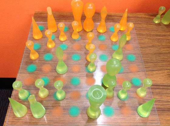 A chess board with orange and green pieces