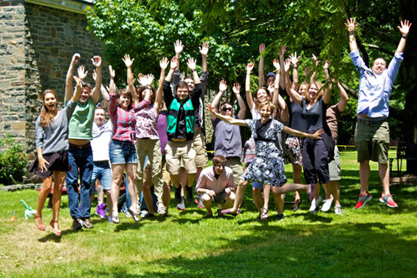 A team photo of the DragonSearch agency in a field jumping in the air