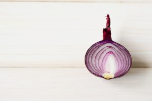 half a red onion on a wooden table