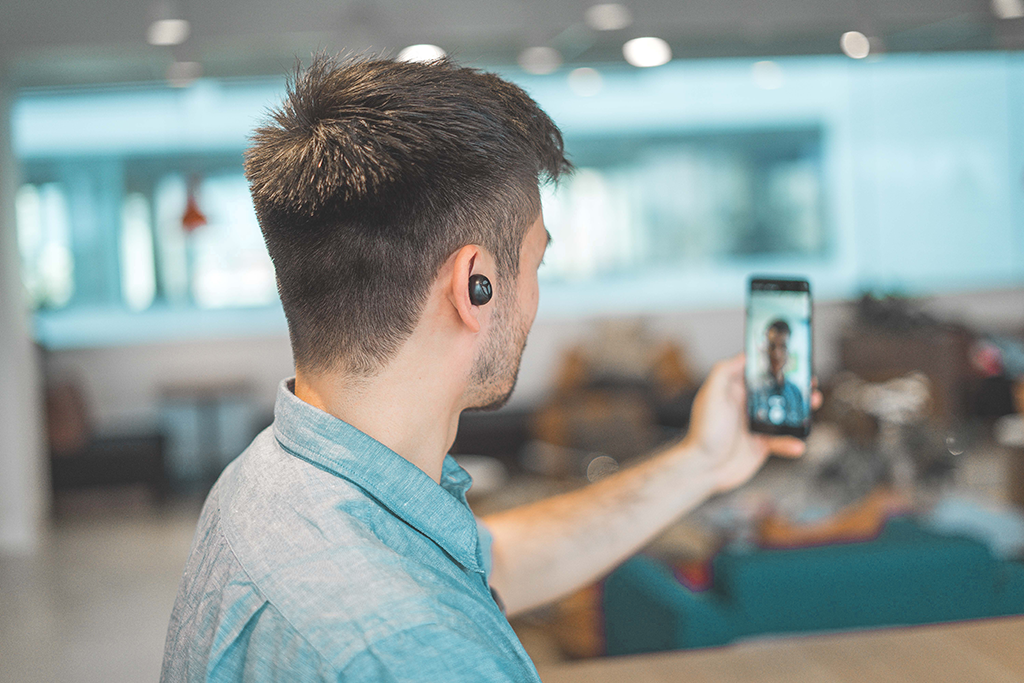 man holding phone on a video call with client - Dragon360