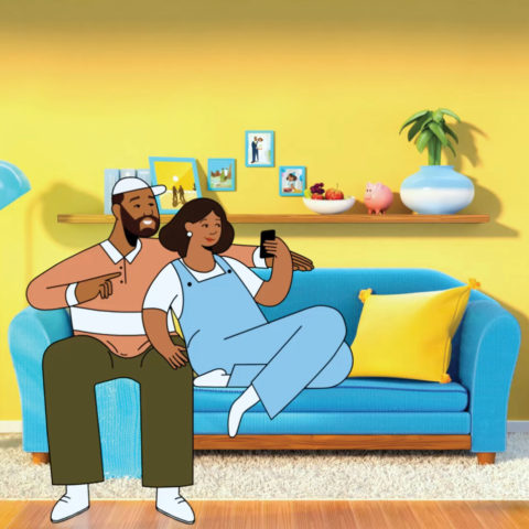 newlyweds sitting on couch together, looking at phone